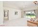 Spacious living room with neutral carpet, slider to patio, and a connecting doorway to a bedroom at 987 Princeton Dr, Clermont, FL 34711