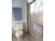 A bathroom featuring a toilet, towel rack, and shower with glass door and a blue and white striped towel at 1014 Dustin Dr, Lady Lake, FL 32159