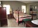 Inviting bedroom with a four-poster bed, hardwood floors, and mirrored closet doors at 1014 Dustin Dr, Lady Lake, FL 32159