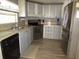 Well-lit kitchen featuring gray cabinets, stainless steel appliances, and wood-look vinyl flooring at 1014 Dustin Dr, Lady Lake, FL 32159
