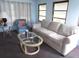 A cozy living room with sofa, chair, glass coffee table and two windows allowing natural light at 1014 Dustin Dr, Lady Lake, FL 32159