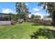 Large backyard with mature trees, a storage shed, and play equipment, ideal for Gathering enjoyment at 1016 Cottonwood St, Leesburg, FL 34748