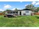 Spacious backyard with a well-maintained lawn and inviting patio with outdoor seating at 1016 Cottonwood St, Leesburg, FL 34748