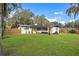 Spacious backyard with a well-maintained lawn and view of the home's screened porch at 1016 Cottonwood St, Leesburg, FL 34748