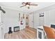 Bright bedroom with hardwood floors, ceiling fan, and guitars on the wall at 1016 Cottonwood St, Leesburg, FL 34748