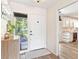 Bright foyer featuring a front door, cabinet, and glimpses of the kitchen at 1016 Cottonwood St, Leesburg, FL 34748