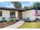 Welcoming home entrance with painted brick, walkway, and landscaped plantings at 1016 Cottonwood St, Leesburg, FL 34748