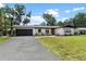 Charming home featuring a well-manicured lawn and a spacious driveway at 1016 Cottonwood St, Leesburg, FL 34748
