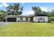 Charming single-story home with a well-manicured lawn and an attached garage at 1016 Cottonwood St, Leesburg, FL 34748
