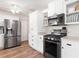 Bright kitchen featuring stainless steel appliances, white cabinetry, and plenty of storage at 1016 Cottonwood St, Leesburg, FL 34748