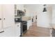 Well-lit kitchen featuring stainless steel appliances, white cabinets, and wood-look flooring at 1016 Cottonwood St, Leesburg, FL 34748