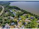 An aerial view highlighting waterfront property, lush greenery and neighborhood at 111 Cardinal Ln, Eustis, FL 32726