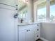 Bright bathroom with a large window, granite countertop, and white cabinetry at 111 Cardinal Ln, Eustis, FL 32726