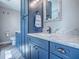 This bathroom boasts blue cabinetry, a granite countertop, modern fixtures, and a clean, updated design at 111 Cardinal Ln, Eustis, FL 32726