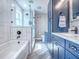 The bathroom is complete with a large tub, glass-enclosed shower, and sleek blue cabinetry at 111 Cardinal Ln, Eustis, FL 32726