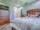 Cozy bedroom featuring wood flooring, a ceiling fan, and a large bed with decorative pillows at 111 Cardinal Ln, Eustis, FL 32726