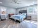 Bedroom features wood-look flooring, a queen sized bed, ceiling fan, and natural light from windows at 111 Cardinal Ln, Eustis, FL 32726