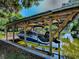 View of the covered boat lift and dock with a boat secured at 111 Cardinal Ln, Eustis, FL 32726