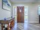 Inviting foyer with wood-look floors, decorative table, and sidelights flanking the front door at 111 Cardinal Ln, Eustis, FL 32726