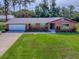 Charming brick home with a well-maintained lawn, lush landscaping, and a two-car garage at 111 Cardinal Ln, Eustis, FL 32726