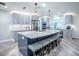 Spacious kitchen boasts an island with seating, stainless steel appliances and stylish gray cabinetry and light wood-look flooring at 111 Cardinal Ln, Eustis, FL 32726