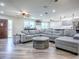 Open-concept living area with a comfortable gray sectional and access to the kitchen at 111 Cardinal Ln, Eustis, FL 32726