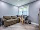 Office space featuring a comfortable sofa, a large window with curtains, and a functional desk area at 111 Cardinal Ln, Eustis, FL 32726