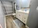 Bathroom featuring gray walls, wood look flooring, white vanity, and shower/tub at 11301 Via Mari Cae Ct, Clermont, FL 34711