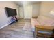 Cozy bedroom area with gray walls, wood-look floors, TV, and a futon sofa, perfect for relaxing at 11301 Via Mari Cae Ct, Clermont, FL 34711