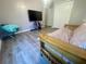 A bedroom featuring neutral gray walls, wood-look floors, TV, a futon sofa and updated closet at 11301 Via Mari Cae Ct, Clermont, FL 34711