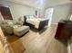 Well-lit bedroom with a comfy arm chair and ottoman, plus hard surface floors at 11301 Via Mari Cae Ct, Clermont, FL 34711
