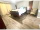Spacious bedroom with neutral walls and wood-look floors, plus comfy chair at 11301 Via Mari Cae Ct, Clermont, FL 34711