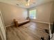 Bedroom with wood-look flooring, a ceiling fan, a window and a futon couch at 11301 Via Mari Cae Ct, Clermont, FL 34711