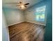Bedroom with a window, modern ceiling fan, wood-look flooring, and white walls, offering a simple and neutral space at 11301 Via Mari Cae Ct, Clermont, FL 34711