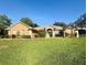 Well-maintained single-story home with a manicured lawn and mature landscaping at 11301 Via Mari Cae Ct, Clermont, FL 34711