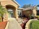 Charming home exterior featuring a stone-accented entryway and meticulously maintained landscaping at 11301 Via Mari Cae Ct, Clermont, FL 34711