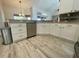 Features a stainless steel dishwasher and sink along with white cabinetry and tiled backsplash at 11301 Via Mari Cae Ct, Clermont, FL 34711