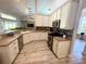 Bright kitchen featuring white cabinetry, stainless steel appliances, and wood-look flooring at 11301 Via Mari Cae Ct, Clermont, FL 34711
