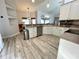 Kitchen featuring white cabinets, stainless steel appliances, and hardwood flooring, offering modern amenities at 11301 Via Mari Cae Ct, Clermont, FL 34711