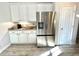 Kitchen featuring white cabinets, stainless steel appliances, and hardwood flooring, offering modern amenities at 11301 Via Mari Cae Ct, Clermont, FL 34711