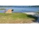 Scenic lake view featuring a wooden dock and a concrete boat ramp amidst lush greenery at 11301 Via Mari Cae Ct, Clermont, FL 34711