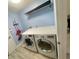 Well-equipped laundry room features modern washer and dryer, shelving, and ample countertop space at 11301 Via Mari Cae Ct, Clermont, FL 34711