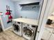 Convenient laundry room with modern washer and dryer, countertop, and a useful hanging rack at 11301 Via Mari Cae Ct, Clermont, FL 34711