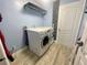A laundry room featuring a front-load washer and dryer set and modern decor at 11301 Via Mari Cae Ct, Clermont, FL 34711