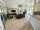 Expansive living room featuring vaulted ceilings, hardwood floors, and an abundance of natural light from large windows at 11301 Via Mari Cae Ct, Clermont, FL 34711
