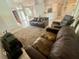 Comfortable living room with neutral rug, leather sofas, and open access to the kitchen at 11301 Via Mari Cae Ct, Clermont, FL 34711