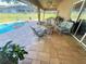 Covered patio with stylish outdoor seating, a fire pit, and access to a private pool at 11301 Via Mari Cae Ct, Clermont, FL 34711