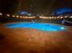 Sparkling in-ground pool with ambient lighting enhances the backyard's evening appeal at 11301 Via Mari Cae Ct, Clermont, FL 34711