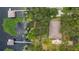 Aerial view of a lakefront home featuring a private dock, mature trees, and a peaceful waterfront setting at 12104 Elbert St, Clermont, FL 34711