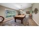 Billiards room with vaulted ceilings, natural light, and a window view. Pool table and accessories at 12104 Elbert St, Clermont, FL 34711